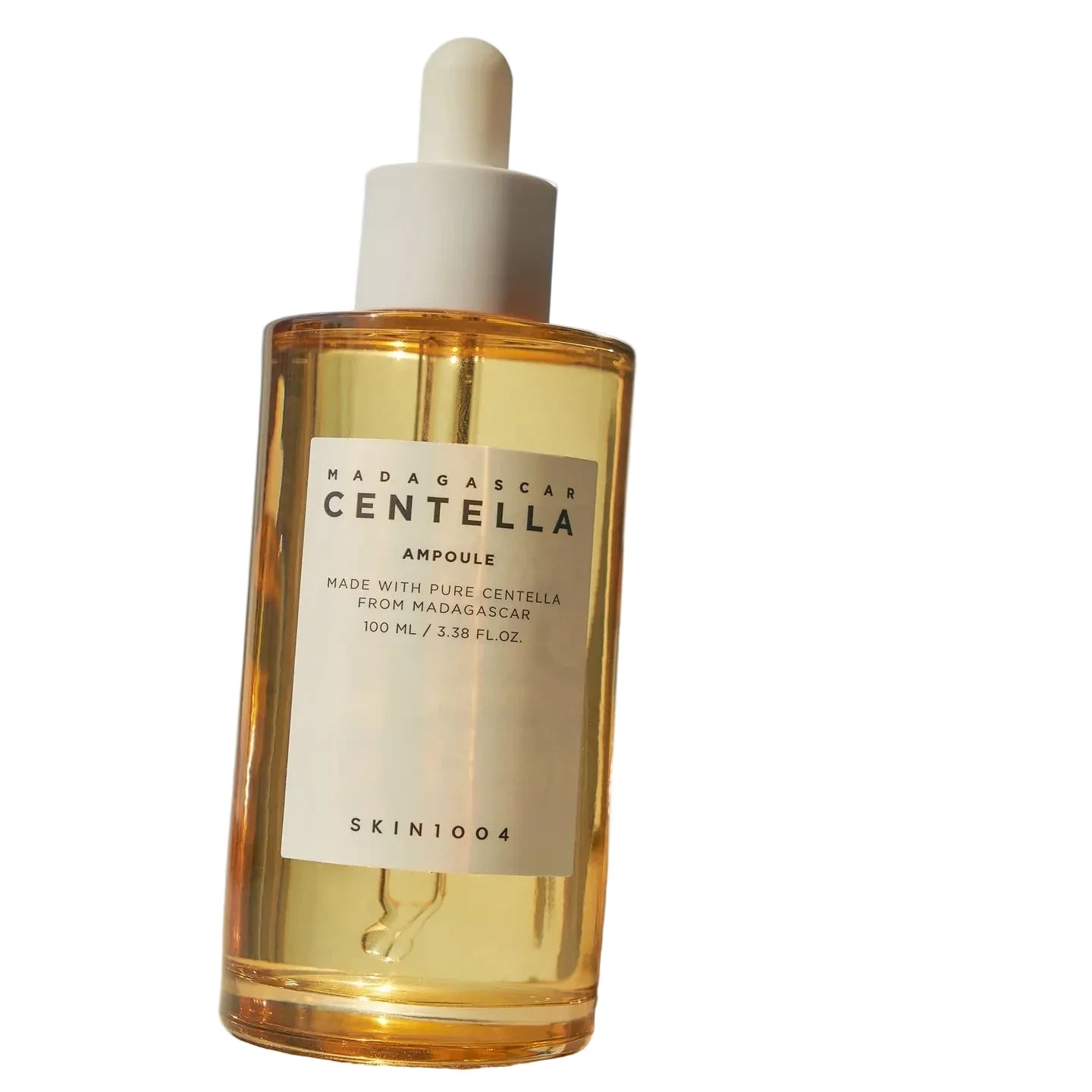 Skincare bottle labeled 'Madagascar Centella Ampoule' with a dropper on a light blue background.